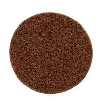 Round abrasive sanding pad on white background.