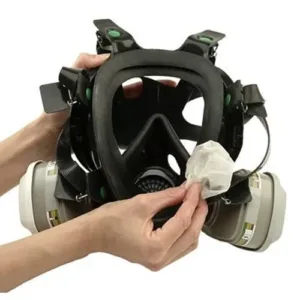 Cleaning a gas mask with a cloth