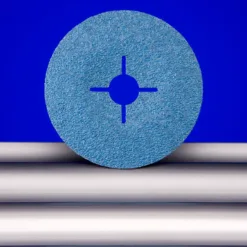 Blue abrasive disc on metal rods, blue background.