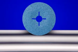 Blue abrasive disc on metal rods, blue background.