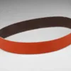 Orange abrasive sanding belt on white background.