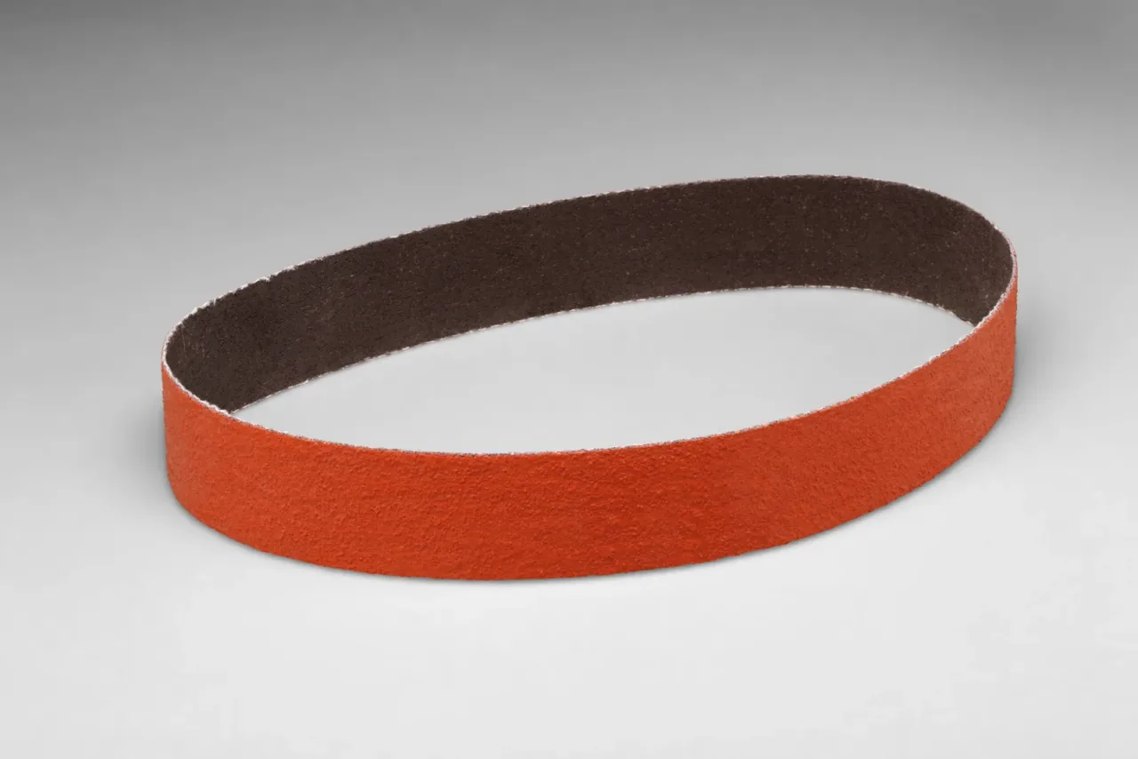 Orange abrasive sanding belt on white background.