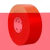 Red masking tape roll on colorful background.