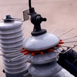 Bird-repellent spikes on electrical insulator equipment.