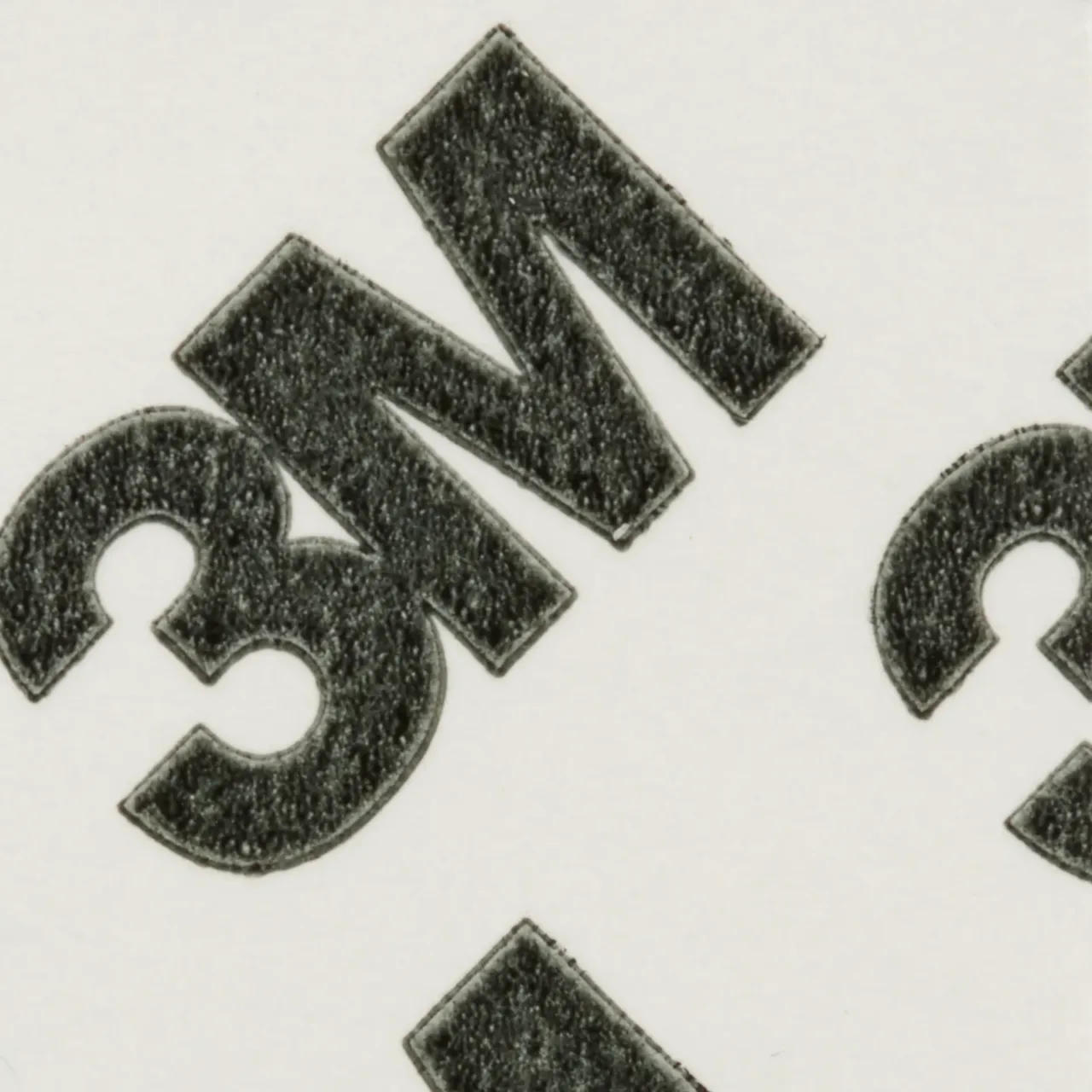 Close-up of black 3M logo on white background.