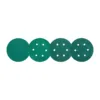Four green sanding discs with holes
