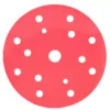 Red sanding disc with multiple holes.