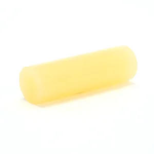 Yellow cylindrical beeswax block on white background.