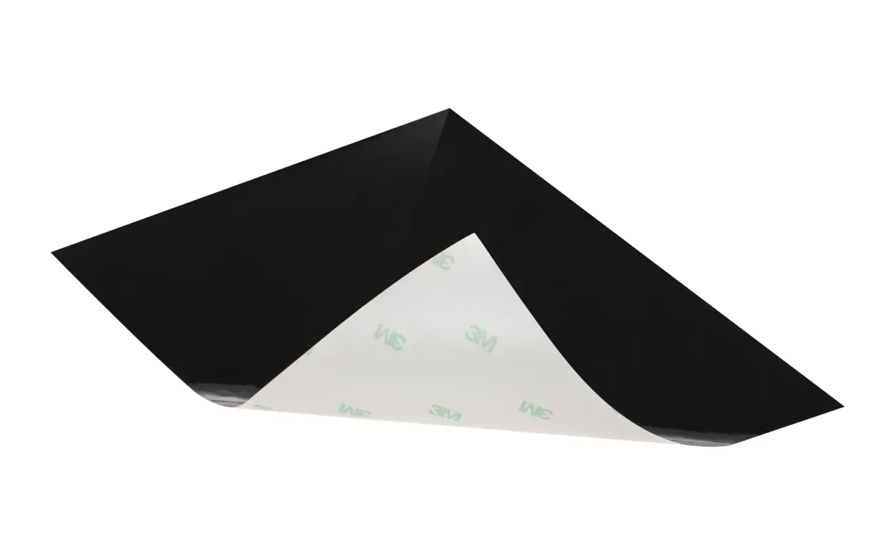 Black adhesive sheet with one corner lifted