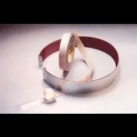 Coiled metallic tape on white surface