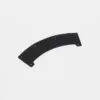 Curved perforated black plastic piece on white background.