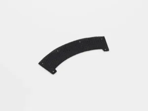 Curved perforated black plastic piece on white background.