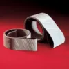 Two coiled sanding belts on red background.